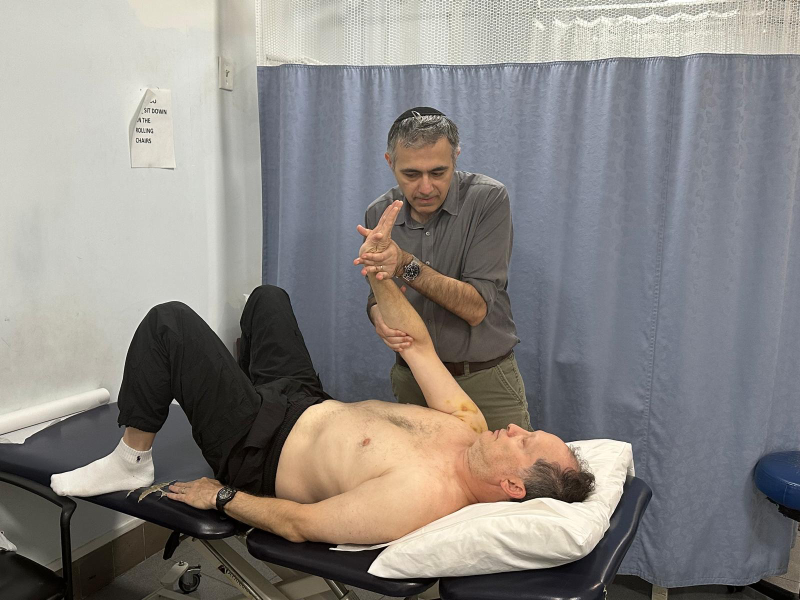 Doctor providing shoulder pain treatment to patient